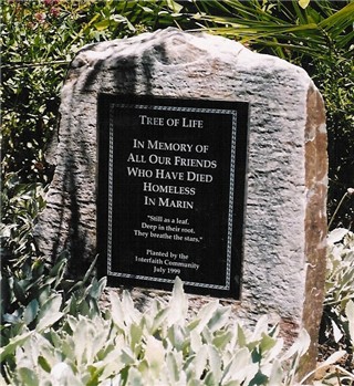 photo of memorial stone which  reads "in memory of all our friends who have died on the streets of Marin"